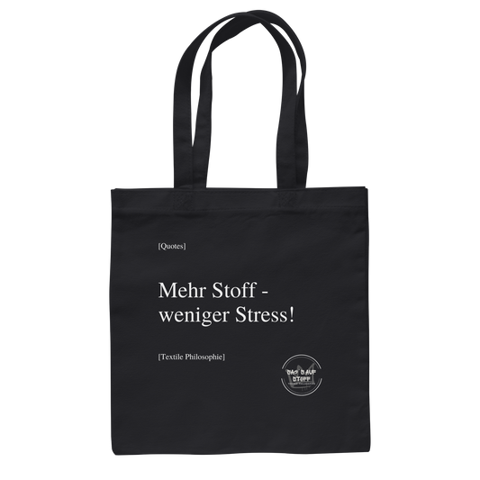 Schwarzer Jutebeutel mit weißer Aufschrift "Mehr Stoff - weniger Stress!" und Logo "Sag´s auf Stoff"