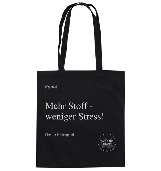 Schwarzer Jutebeutel mit weißer Aufschrift "Mehr Stoff - weniger Stress!" und Logo "Sag´s auf Stoff"