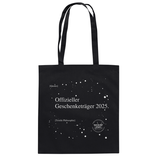 Schwarzer Jutebeutel von „Sag’s auf Stoff“ mit weißer Aufschrift "Offizieller Geschenketräger 2025.", Weißen Schneeflocken im Hintergrund und Logo "Sag´s auf Stoff". Perfekt als Geschenk.