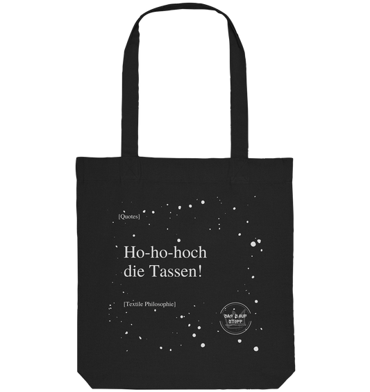 Schwarzer Jutebeutel von „Sag’s auf Stoff“ mit weißer Aufschrift "Ho-ho-hoch die Tassen!", Weißen Schneeflocken im Hintergrund und Logo "Sag´s auf Stoff". Perfekt als Geschenk.