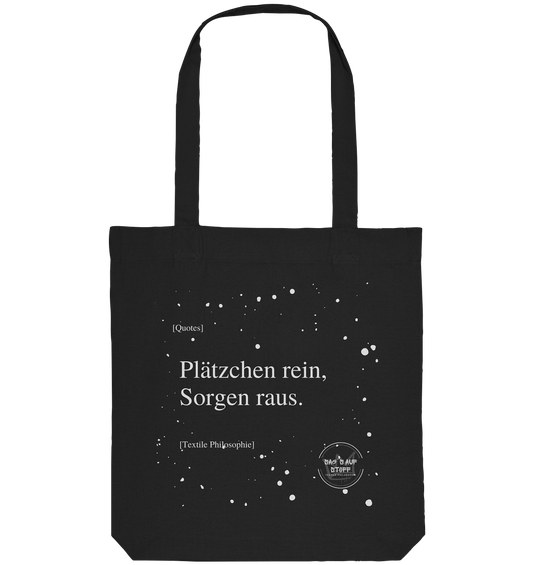 Schwarzer Jutebeutel von „Sag’s auf Stoff“ mit weißer Aufschrift "Plätzchen rein, Sorgen raus.", Weißen Schneeflocken im Hintergrund und Logo "Sag´s auf Stoff". Perfekt als Geschenk.
